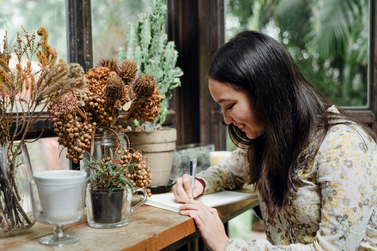 Image of woman smiling while drawing peacefully in Art Therapy